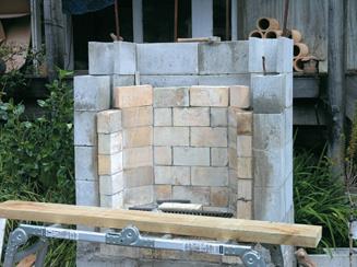 Fireplace hearth with scoria-cement mix layer between bricks and outer wall
