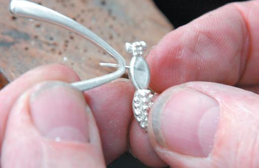 Use silver wire to peg wings in place.
