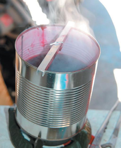 Boil dye for ten minutes, suspend spoon in it for 30 minutes.