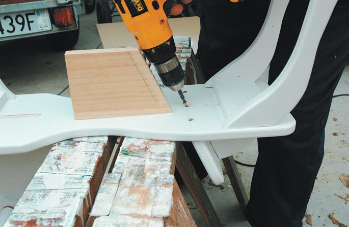 Screwing the mounting screws in the seat back, The old template piece serves as a guide.