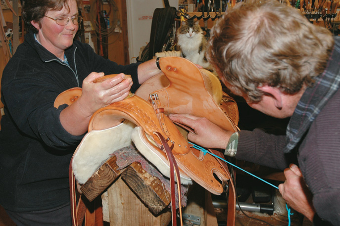Jane helps as Graeme pulls leathers through beneath the skirt