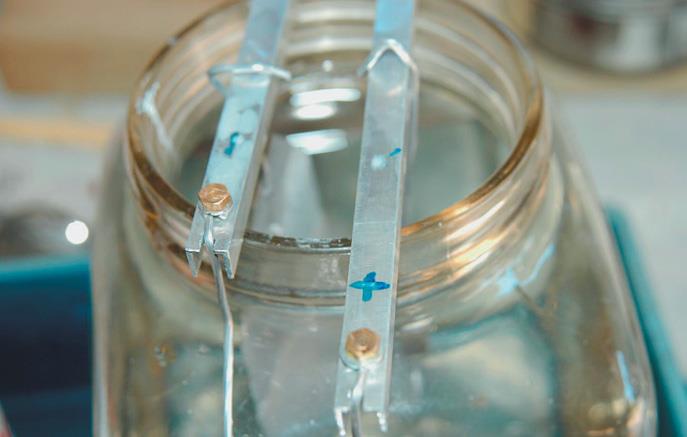 Spoon is suspended from positive terminal or bar.