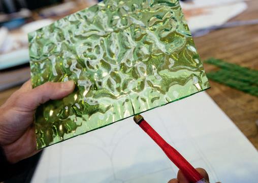 Tapping the glass along the score line.