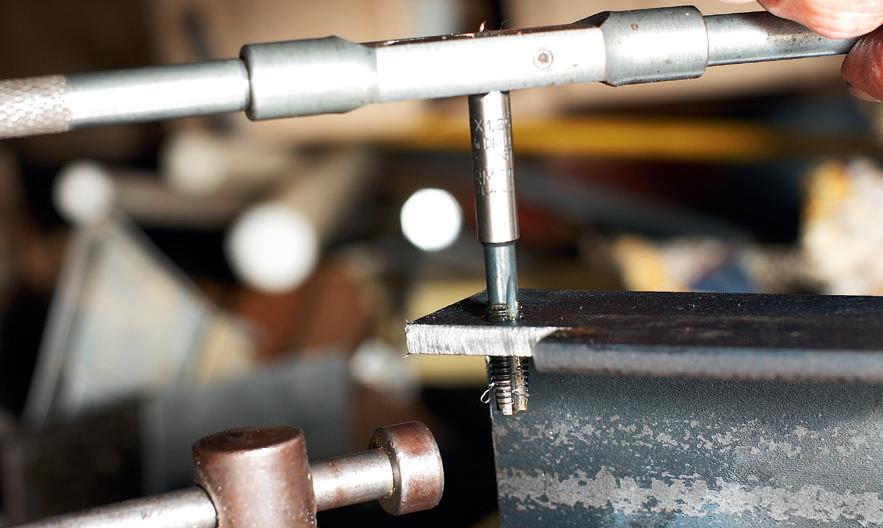Tapping the thread by hand.