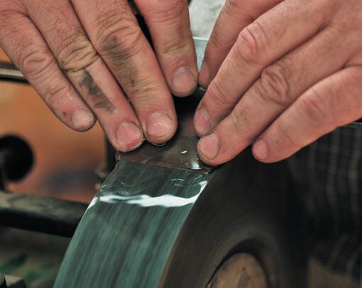 Grinding. Note water cooling the blade