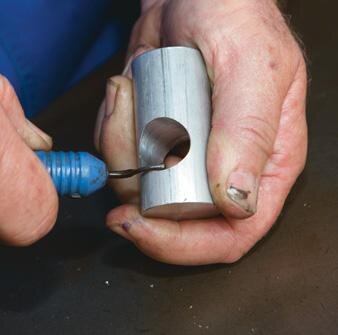 Deburring tool breaks sharp edge of hole